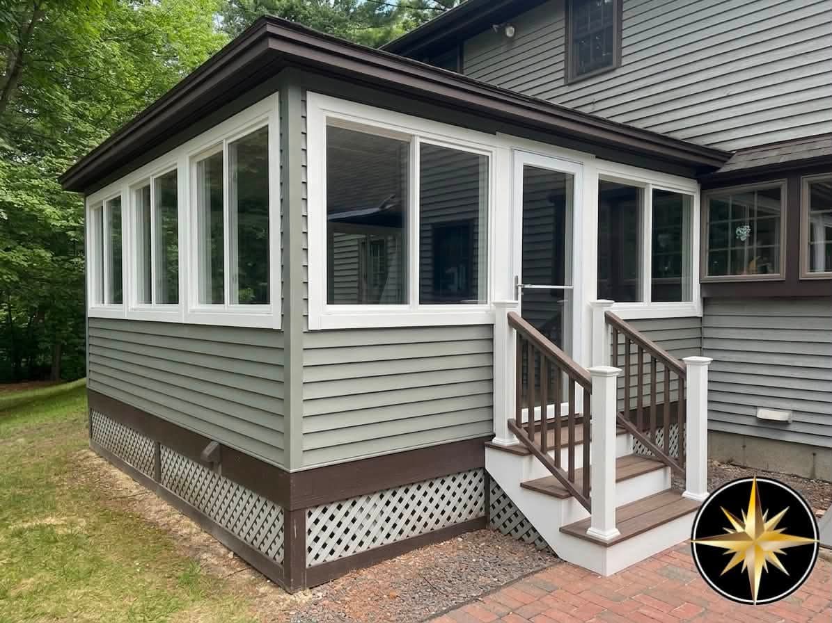 After: enclosed three-season sunroom with gray siding, white trim, new windows, and a composite staircase in Atkinson, NH