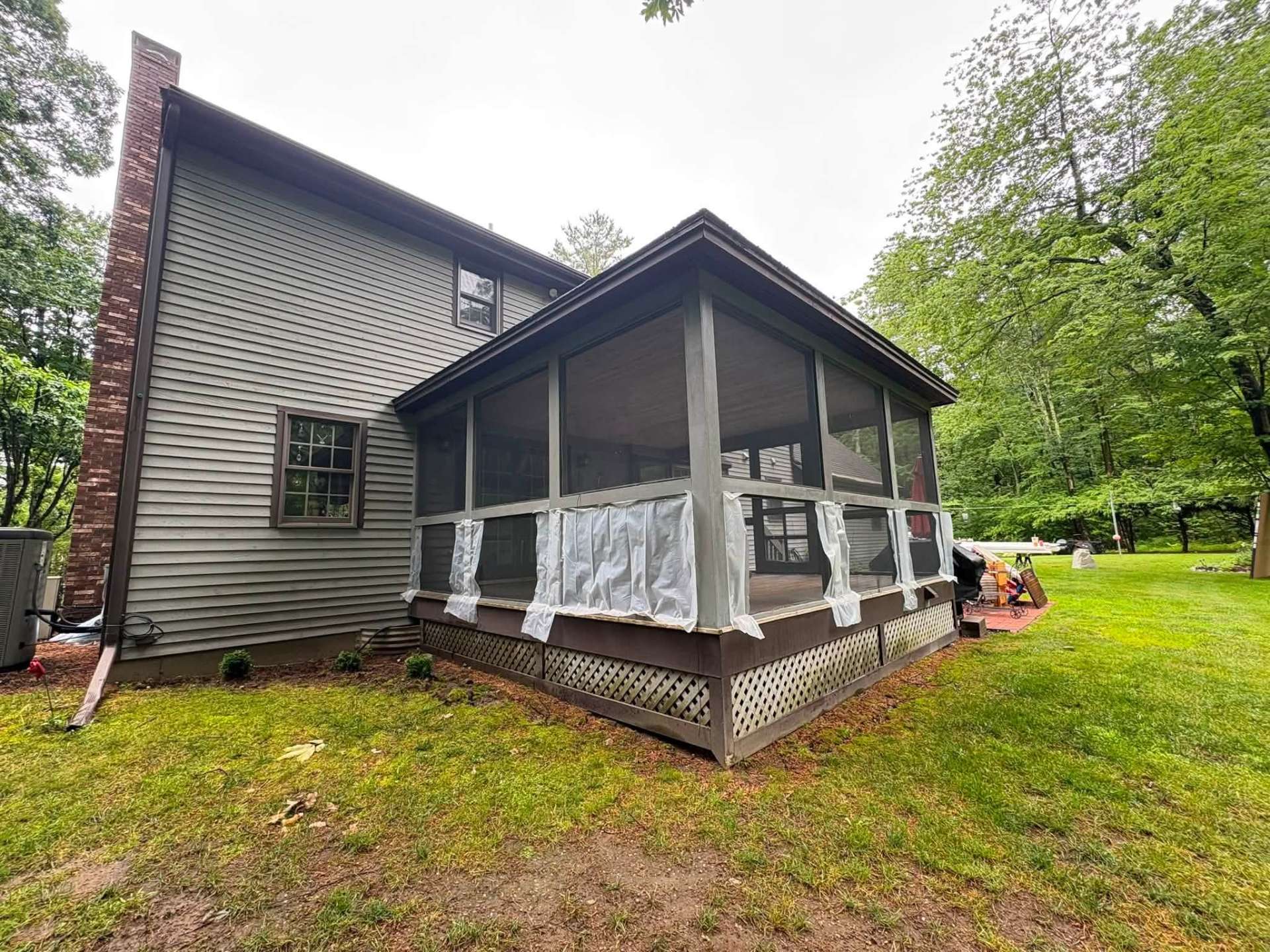 Side view of the Atkinson, NH screened porch during demolition with plastic sheeting over the framing